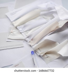 Sewing flat lay with samples of light fabrics, needles and fabrics. Factory production.