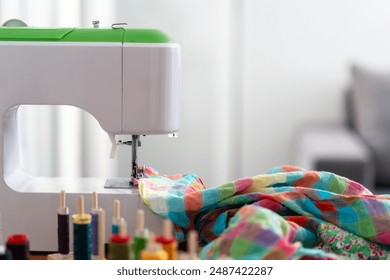 A sewing machine with colorful fabric being stitched, surrounded by vibrant spools of thread. Concepts of creativity and craftsmanship - Powered by Shutterstock