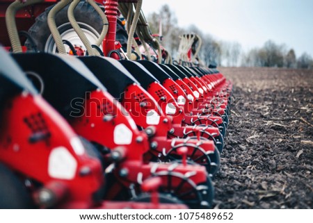 sewing machine with discs stands on the ground in the field in the spring