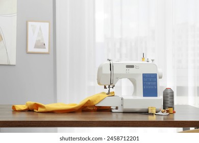 Sewing machine with fabric and craft accessories on wooden table indoors - Powered by Shutterstock