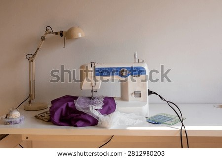 Sewing machine with fabric and tools on worktable
