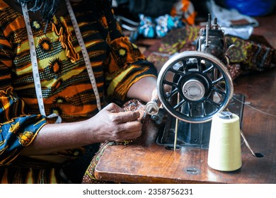 Sewing machine with fabrics, threads and tools in an active sewing workshop in Benin