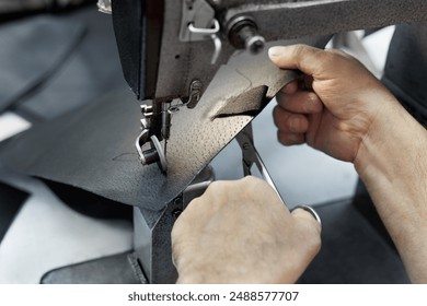 Sewing machine in the leather workshop is in action, hands are working on leather parts for shoes - Powered by Shutterstock