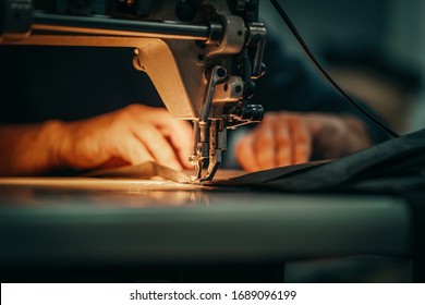 Sewing machine and men's hands of a tailor