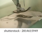 Sewing machine needle and thread close up, shallow depth of field