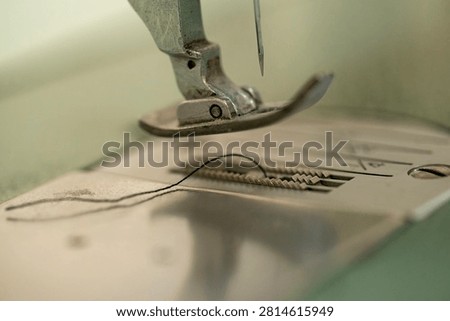 Sewing machine needle and thread close up, shallow depth of field