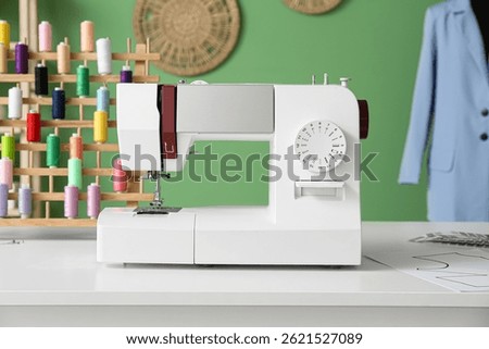 Sewing machine on tailor's table in atelier, closeup