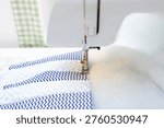 Sewing machine stitching patchwork fabric with padding polyester, quilting process close up