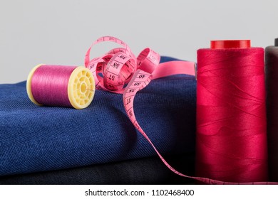 Sewing materials are red bobbins,tape measure on the white background. - Shutterstock ID 1102468400