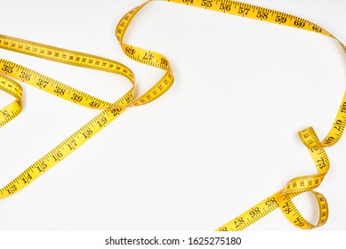 Sewing measuring tape on a white surface. Top view. - Shutterstock ID 1625275180