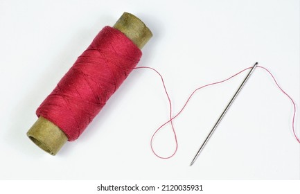 The Sewing Needle Is A Pointed Tool And A Red Thread Threaded Into The Eye Of The Needle. Designed For Stitching Clothing Parts.