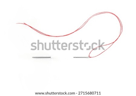 Sewing needle with red thread through the white background	