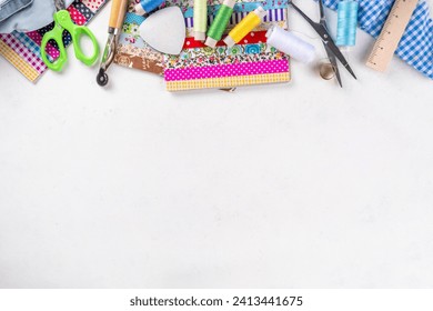 Sewing, needlework and clothing repair, background, scrapbooking, quilting. Colorful pieces of fabric, scissors, ruler, sewing tools, needles, threads on a white table background top view copy space