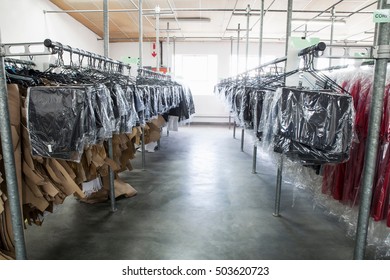 Sewing Patterns And Garments Hanging On Clothes Rail In Sewing Factory Sample Room