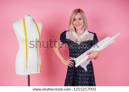 sewing pattern,sewing machine and maniken in studio pink background.seamstress curve template. tailor creates a collection outfits sews clothes in workshop. young woman designer clothes notes ideas