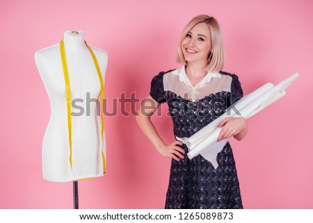 sewing pattern,sewing machine and maniken in studio pink background.seamstress curve template. tailor creates a collection outfits sews clothes in workshop. young woman designer clothes notes ideas