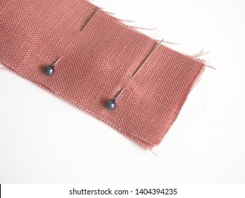 Sewing Pins In Linen Fabric On White Background, Sewing Pin Use For Attaching Fabric Together Temporarily Before Sewing It With Hand Or Sewing Machine For The Strong Permanent Stitch.