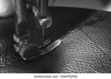 Sewing process of the leather belt. old Man's hands behind sewing. Leather workshop. textile vintage sewing industrial, black and white, b&w
