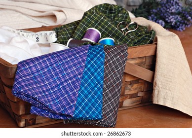 Sewing Or Quilting Still Life.  Basket Of Colorful Cotton Fabric And Sewing Notions.  Folded Quilt And Lavender In Soft Focus In The Background.