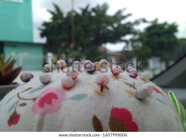 Sewing\
straight pins with heads of various colors in\
car
