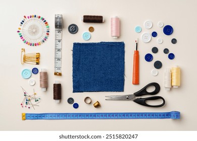 Sewing supplies and denim fabric arranged on a workspace for clothing alterations in a bright setting - Powered by Shutterstock