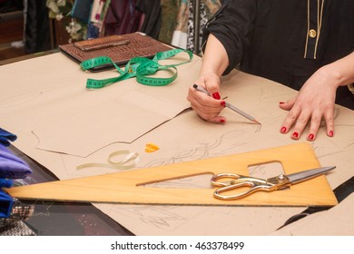 Sewing textile or cloth. Work table of a tailor. Textile tools. Scissors reel of thread, measuring tapes and natural fabric. Copy space.