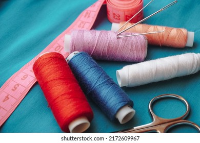 Sewing Thread, Scissors Needle Close Up On A Blue Background.