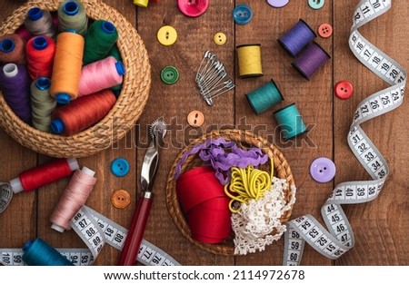 Sewing tool for needlework, colored threads centimeter and buttons with a pair of scissors on the table. close-up.