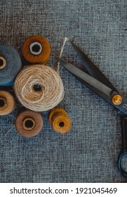 sewing tools. black scissors, spools of thread on baggy fabric. horizontal photo. Needlework tool. retro sewing tools: old scissors, bobbins of thread on gray fabric. Tailor. DIY.