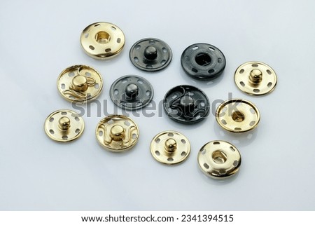 Sew-on button for bags and clothes. Metal fittings for sewing clothes and accessories. Components of the press-stud with a flat top on a white background close-up.