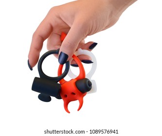 Sex toys in a female hand on a white background, rings.