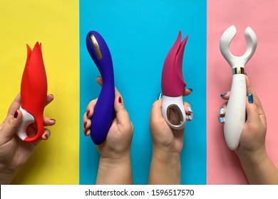 Sex toys. Many hands using vibrators on a bright background. Useful for adult and sex shop