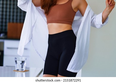 Sexual Fitness Woman With Beautiful  Thin Fit Body Figure And Slim Waist Wearing Sportive Cycling Shorts, Brown Top And White Shirt