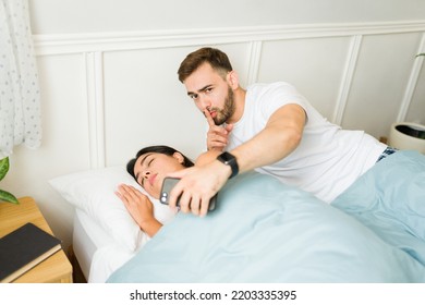 Sexual Harassment Concept. Inappropriate Man Taking A Secret Photo Picture Of A Sleeping Woman Without Consent After Sex