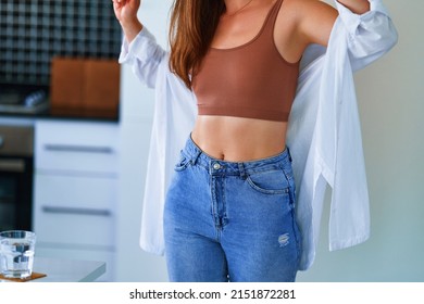 Sexual woman with beautiful thin fit body figure and slim waist wearing jeans, top and white shirt