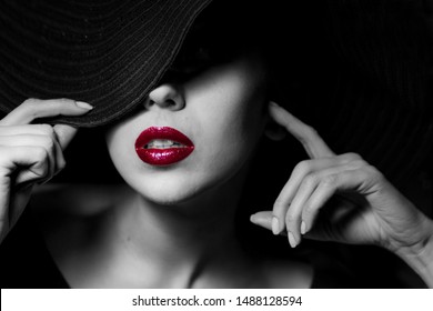 Sexual woman with red lips in black hat. Close-up high fashion portrait. Mysterious black and white image. Sensuality. Sexuality. Femme Fatale style. 