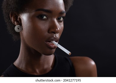 Sexy African American Woman Smoking Cigarette On Black Dark Background.