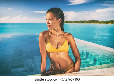 Sexy Asian Bikini Model Woman Sun Tanning In Infinity Pool At Luxury Hotel In Bora Bora , Tahiti, French Polynesia. Swimsuit Body Summer Vacation Travel Tan.