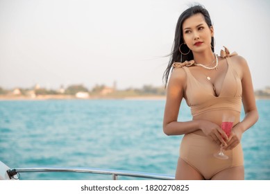 Sexy Asian Women In Bikini With Champagne Glass On Her Private Yacht.