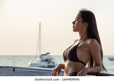 Sexy Asian Women In Black Bikini At Sunset On Her Private Yacht.