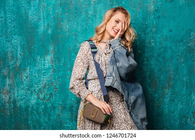 Sexy Attractive Stylish Blonde Woman In Jeans Oversize Jacket Walking Against Vintage Green Wall In Street Sexy Attractive Stylish Blonde Woman In Jeans Oversize Jacket Walking Against Vintage Green Wall In Street