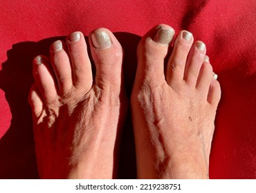 Woman’s Sexy Bare Feet With Toes Spread Against Red Background 