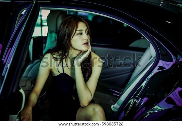 sexy beautiful asia Thai model young lady girl\
posing sitting by a car open door\
