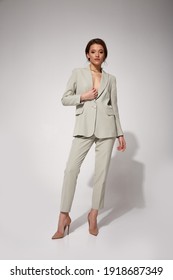 Sexy beautiful business woman lady boss CEO manager makeup hairstyle brunette wear clothes office dress code suit jacket pants uniform high heels work or date catalog accessory jewelry elegant style.