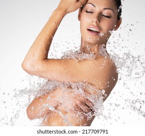 Sexy beautiful naked woman with wet body and splashes of water