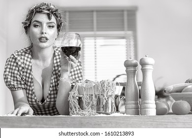 Sexy Beautiful Woman Cooking At Domestic Kitchen. Italian Housewife Doing Homemade Pasta, Drinking Red Wine And Looking At Camera. 