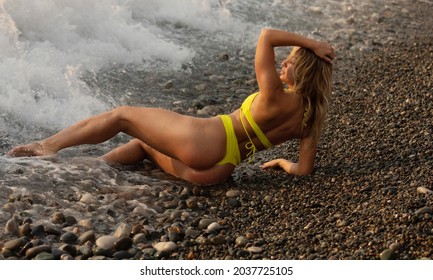 Sexy beautiful woman in yellow bikini on the beach.