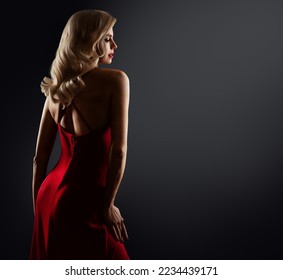 Sexy Blond Hair Woman in Red Dress Back Side view. Beautiful Blonde Girl Silhouette in Backlight. Fashion Model in Red Gown over Black Background. Elegant Lady Face Profile