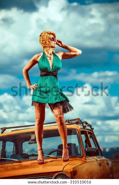 Sexy blond woman on the picnic. Beautiful\
summer clouds on the\
background.