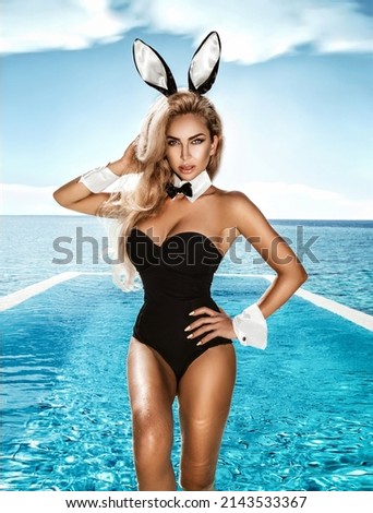 Sexy blonde model dressed in Easter bunny costume and bunny ears is standing in pool on Maldives Island. Halloween and Easter bunny costume - Image. Sexy bunny woman. Bikini woman on Maldives.